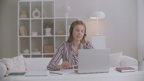 female-student-is-giving-exam-of-foreign-language-online-talking-by-video-chat-on-laptop-distant-mode
